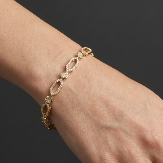 Close-up lifestyle view of a classic 14k white gold or platinum tennis bracelet featuring a continuous uniform row of brilliant round-cut diamonds styled on a wrist.