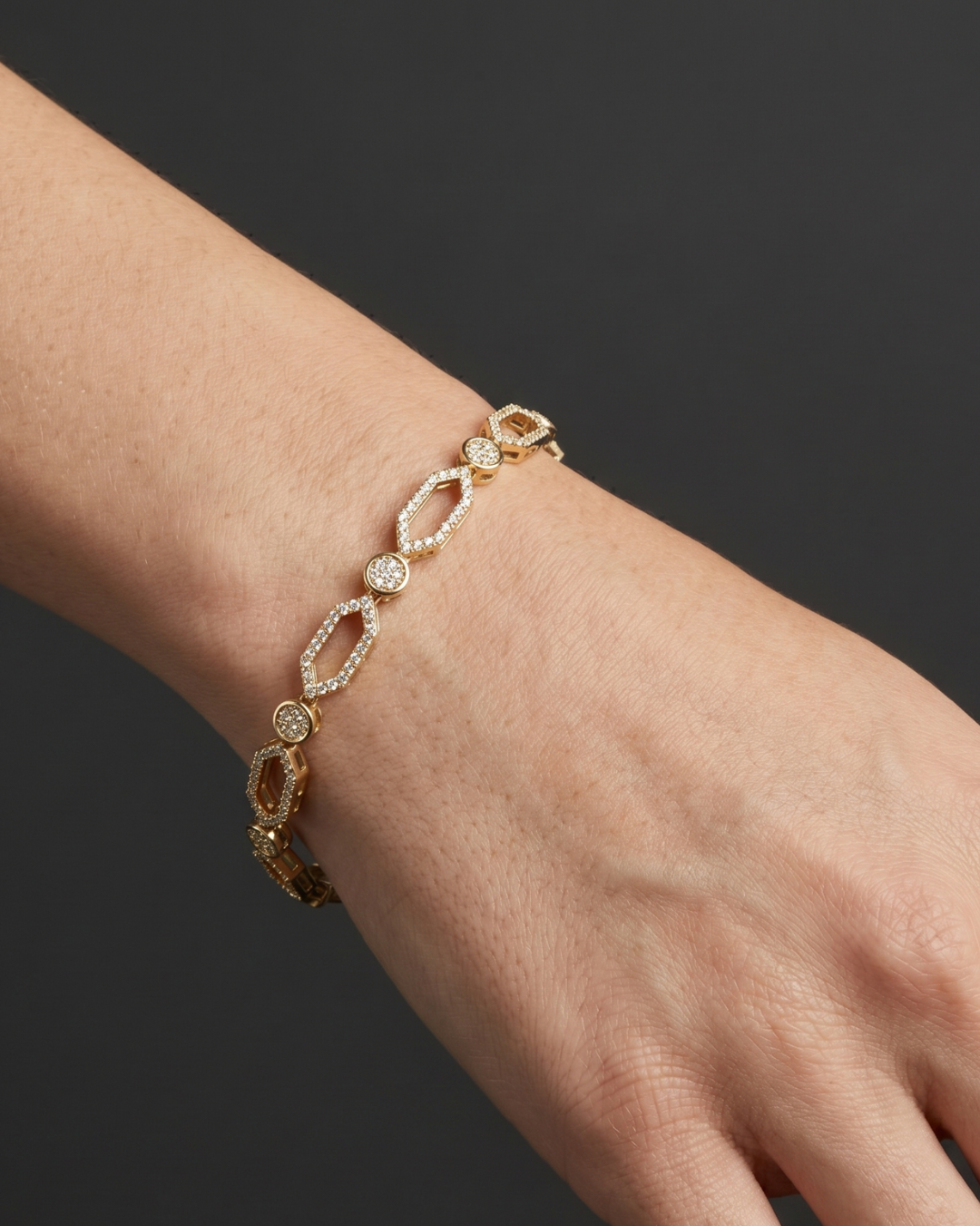 Close-up lifestyle view of a classic 14k white gold or platinum tennis bracelet featuring a continuous uniform row of brilliant round-cut diamonds styled on a wrist.