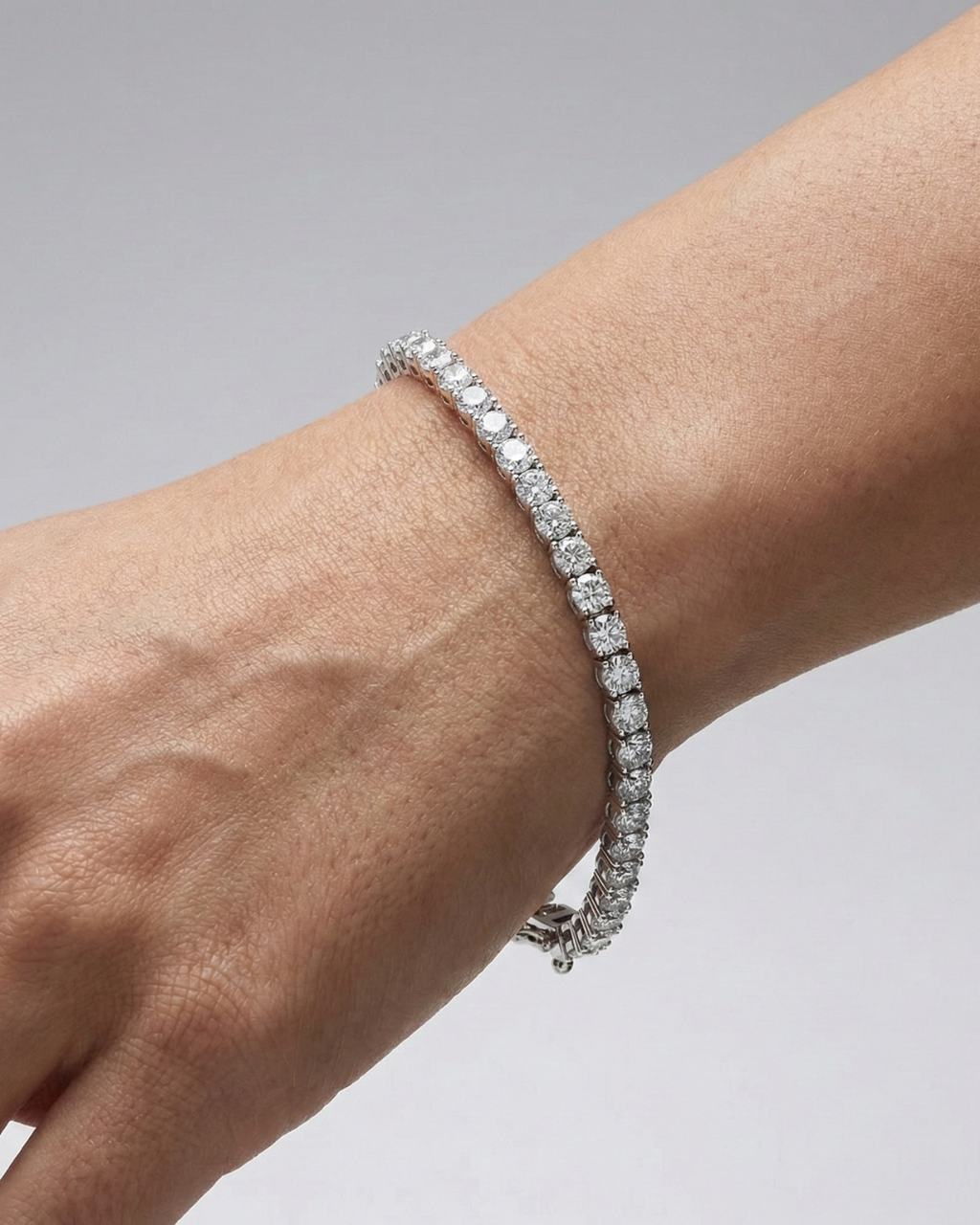 A full top-down view of a 14K white gold tennis bracelet, coiled to show the seamless, continuous line of round diamonds on wrist.