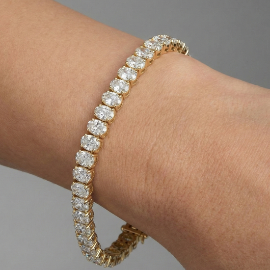 A full top-down view of a 14K yellow gold bracelet, coiled to show the bold, double-line of brilliant diamonds on wrist.
