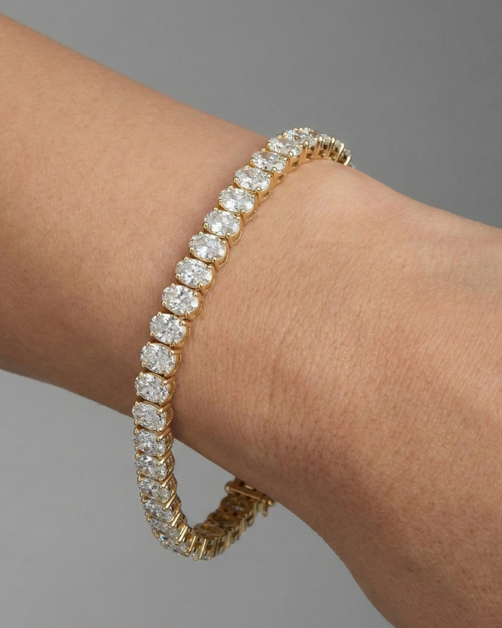 A full top-down view of a 14K yellow gold bracelet, coiled to show the bold, double-line of brilliant diamonds on wrist.