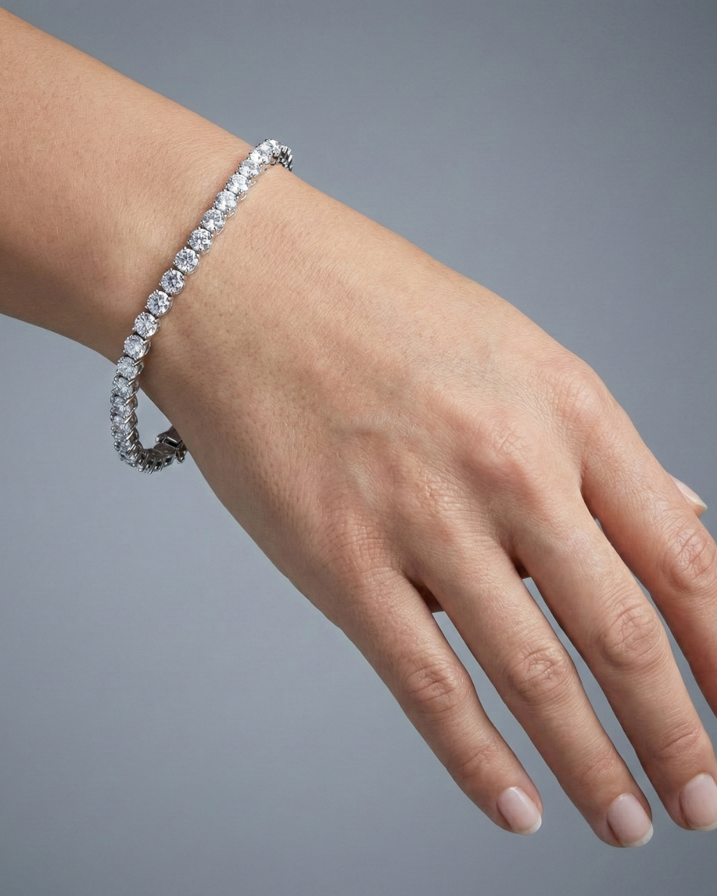 An angled view of the 14K white gold F VS diamond tennis bracelet, showing the gold cup setting and secure clasp on wrist.