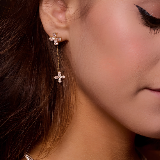 Yellow-gold floral diamond drop earrings worn on the ear, showing graceful movement, balanced proportions, and feminine sparkle.