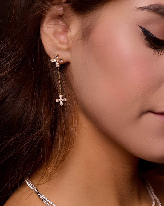 Yellow-gold floral diamond drop earrings worn on the ear, showing graceful movement, balanced proportions, and feminine sparkle.