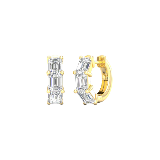 An angled view of a pair of 14K yellow gold huggie hoops, showcasing the linear design of the diamonds.