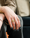 Yellow gold geometric stackable ring worn on a model's hand.