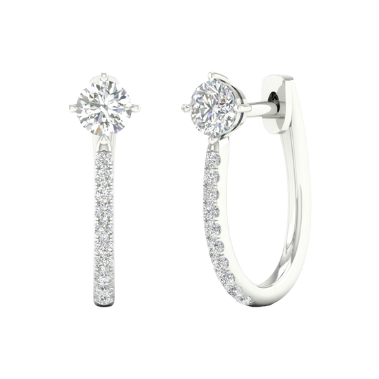 A front and side view of 14K white gold huggie hoops featuring a single top diamond and a pavé diamond drop.