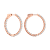 A profile view of 14K rose gold huggie hoop earrings, showing a continuous circle of brilliant, round-cut diamonds on the outer circumference.