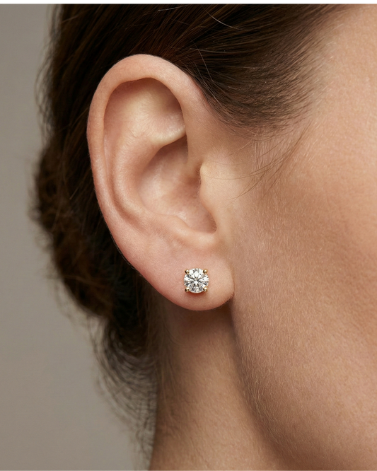 Front view of white gold round solitaire diamond stud earrings featuring brilliant-cut diamonds secured in a classic four-prong setting on ear.