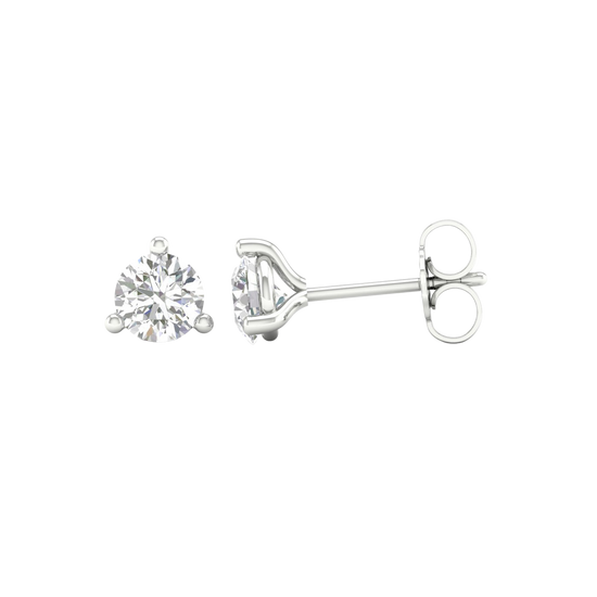 An angled view of a pair of 14K white gold three-prong diamond stud earrings, showcasing the full design.