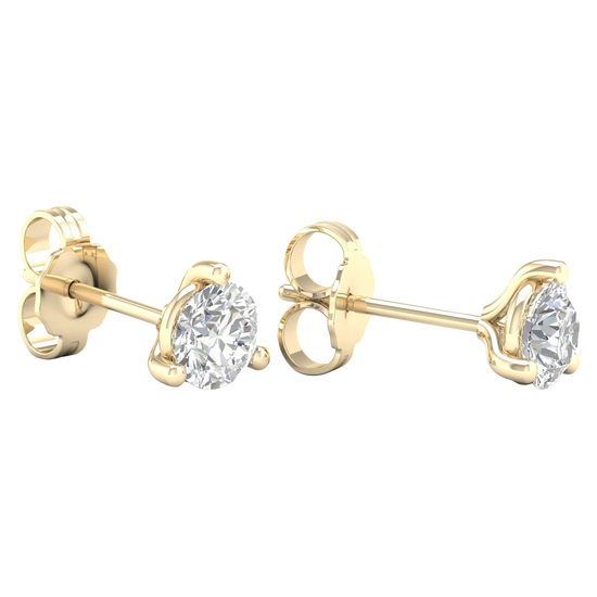 A pair of 14K yellow gold three-prong diamond stud earrings, shown from a side profile.