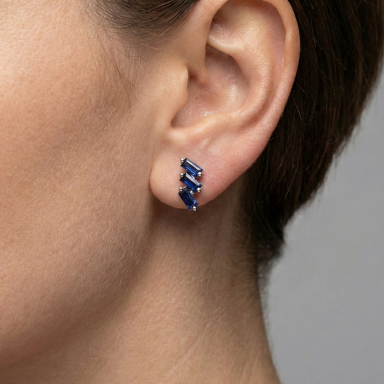 A close-up, profile shot of a person’s ear and jawline, showcasing the Cascading Baguette-Cut Stud Earrings. The model’s hair is swept back, allowing the jewelry to take center stage against a soft-focus, neutral background.