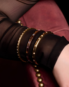 A substantial, high-polish 14k yellow gold wide cuff from the Amorati Fourteen Collection, featuring scattered star and geometric insets with shimmering round lab-grown diamonds, gracefully styled on a model’s wrist.
