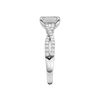 A side view of 14K white gold Amorati Vignette emerald diamond solitaire with prong setting and diamond band