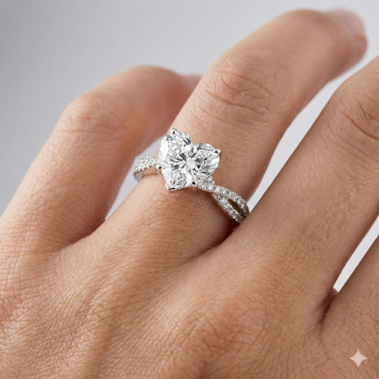 Heart cut diamond engagement ring in 14k white gold with a prong diamond band and twist setting on a hand