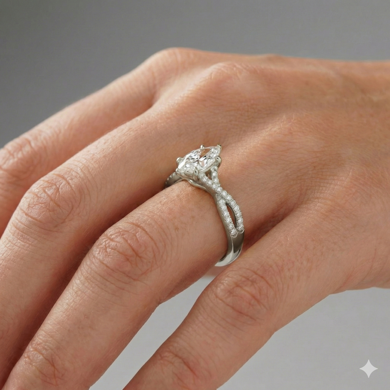Marquise cut diamond engagement ring in 14k white gold with a prong diamond band and twist setting on a hand