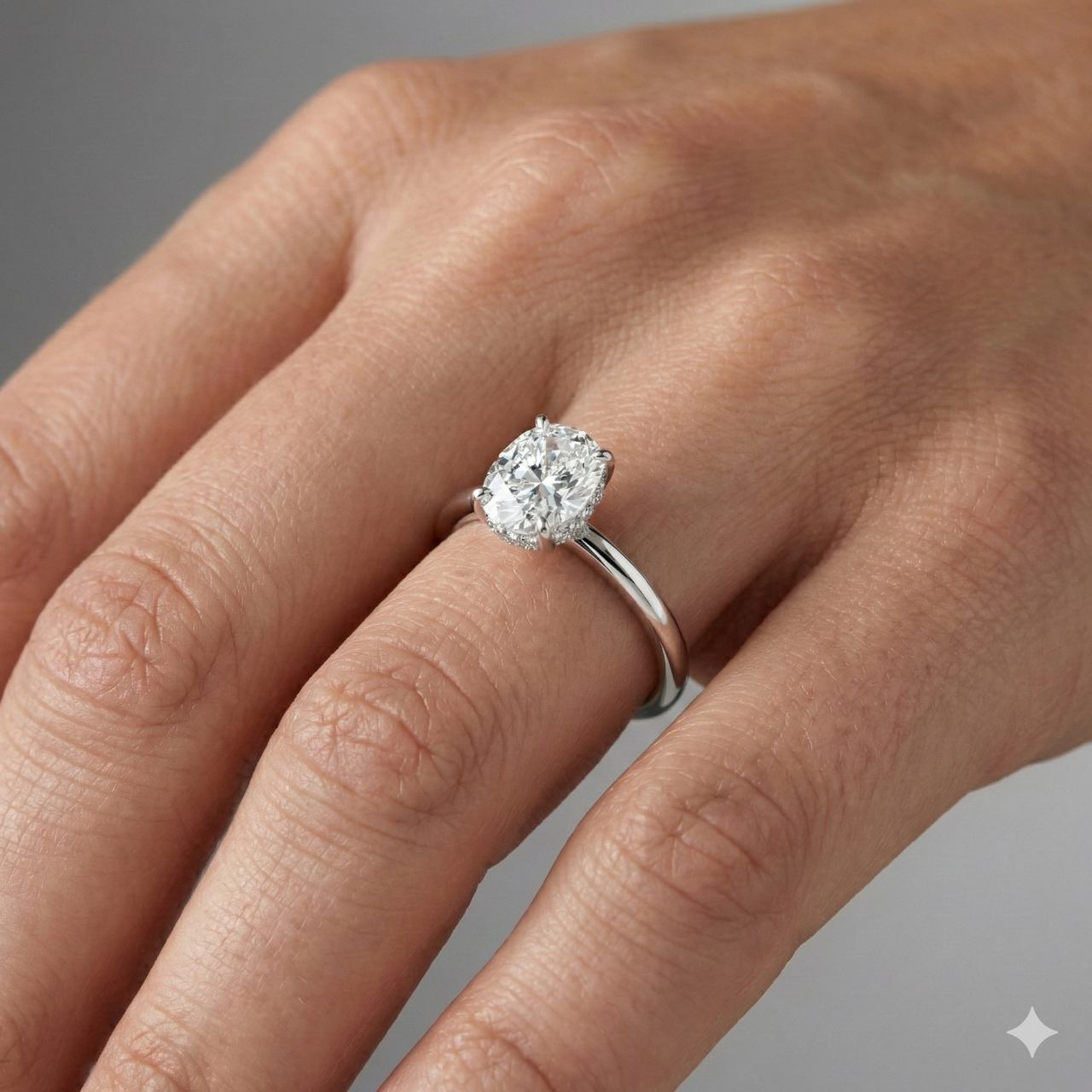 Elongated cushion cut diamond engagement ring in 14k white gold with a plain band and solitaire setting on a hand