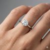 Round cut diamond engagement ring in 14k white gold with a plain band and solitaire setting on a hand