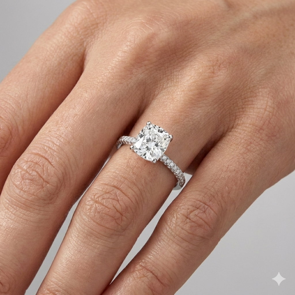 Elongated Cushion cut diamond engagement ring in 14k white gold with a pavé diamond band and cathedral setting on a hand.