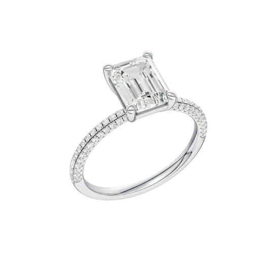A three-quarter view of the Emerald cut diamond engagement ring in platinum with a pavé diamond band and cathedral setting