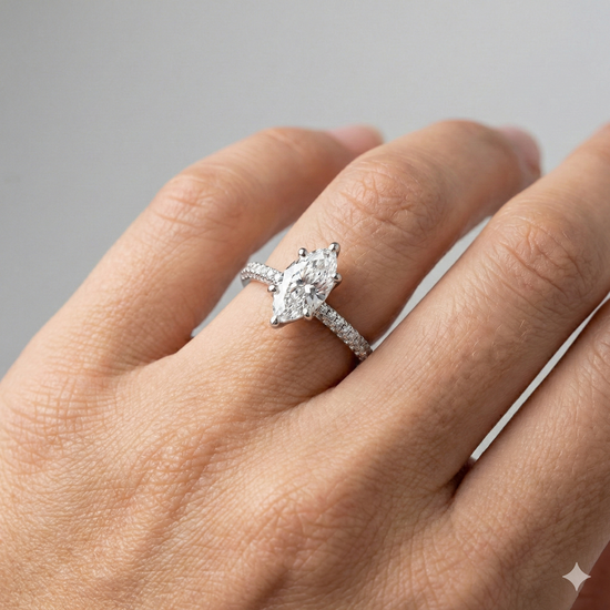 Marquise cut diamond engagement ring in 14k white gold with a pavé diamond band and cathedral setting on a hand