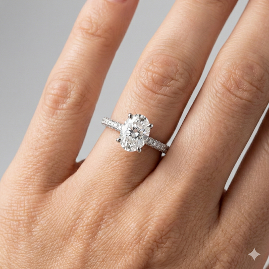 Oval cut diamond engagement ring in 14k white gold with a pavé diamond band and cathedral setting on a hand