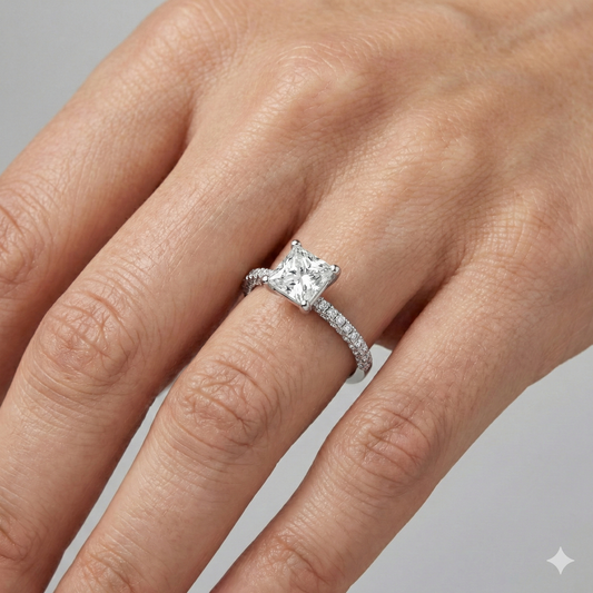 Princess cut diamond engagement ring in 14k white gold with a pavé diamond band and cathedral setting on a hand