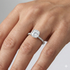 Round cut diamond engagement ring in 14k white gold with a pavé diamond band and cathedral setting on a hand