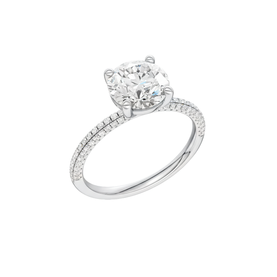 A three-quarter view of the Round cut diamond engagement ring in 14k white gold with a pavé diamond band and cathedral setting