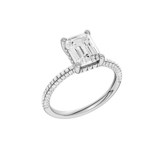 A three-quarter view of the Emerald cut diamond engagement ring in platinum with a pavé diamond band and cathedral setting