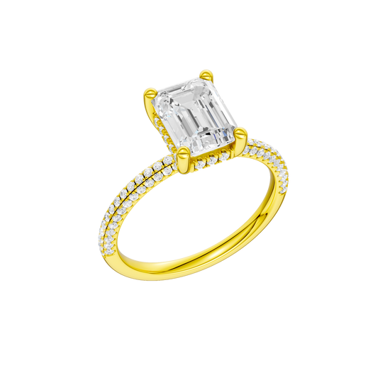 A three-quarter view of the Emerald cut diamond engagement ring in 14k yellow gold with a pavé diamond band and cathedral setting