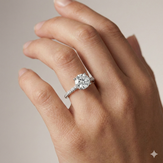 Round cut diamond engagement ring in 14k white gold with a pavé diamond band and cathedral setting on a hand