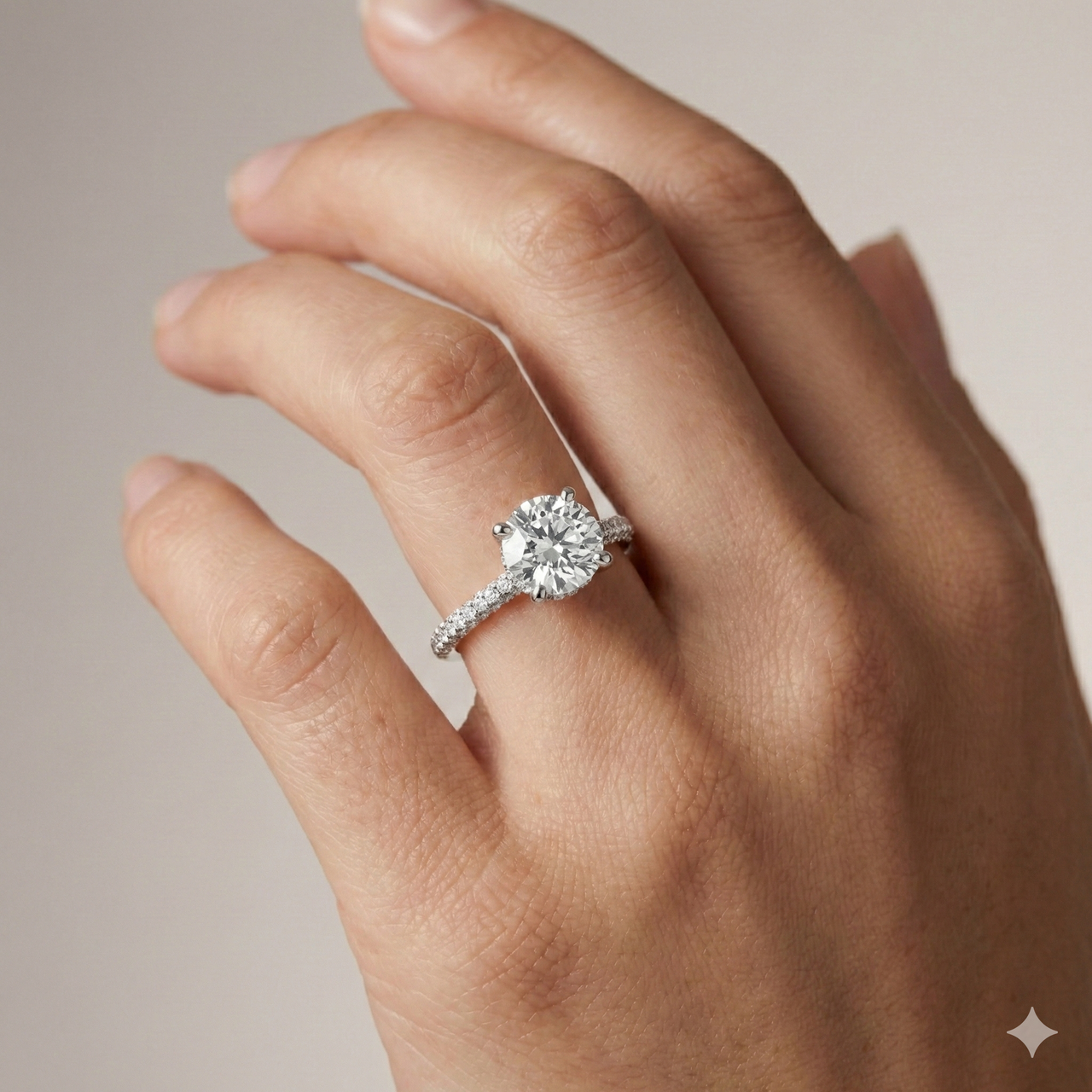 Round cut diamond engagement ring in 14k white gold with a pavé diamond band and cathedral setting on a hand