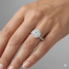 Round cut diamond engagement ring in 14k white gold with a pavé diamond band and solitaire setting on a hand