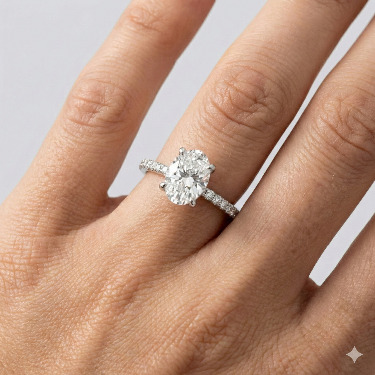 Oval cut diamond engagement ring in 14k white gold with a prong diamond band and cathedral setting on a hand
