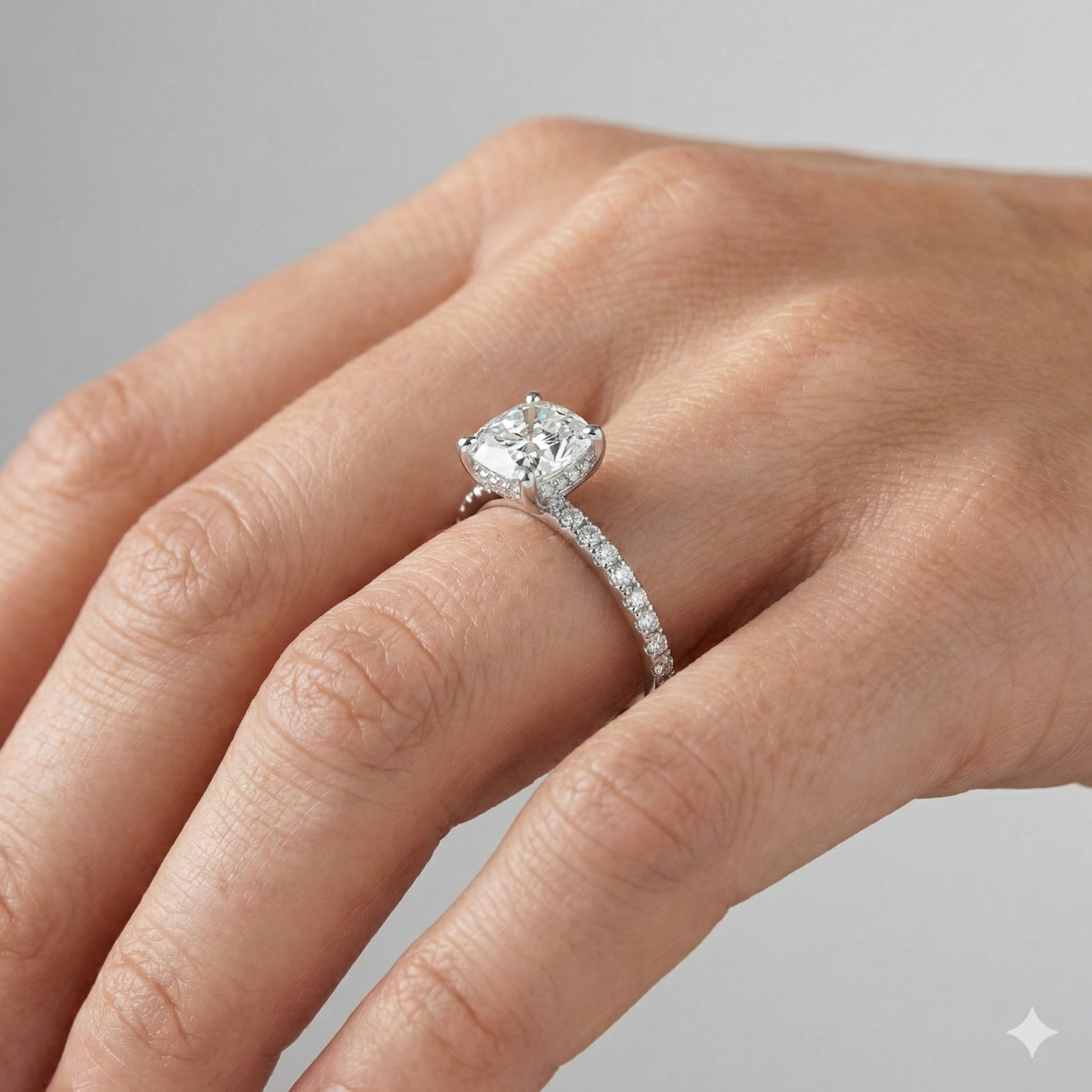 Elongated cushion cut diamond engagement ring in 14k white gold with a prong diamond band and cathedral setting on a hand