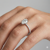 Pear cut diamond engagement ring in 14k white gold with a prong diamond band and cathedral setting on a hand