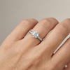 Round cut diamond engagement ring in 14k white gold with a diamond channel band and cathedral setting on a hand