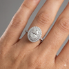 Oval cut diamond engagement ring in 14k white gold with a diamond channel band and cathedral setting on a hand