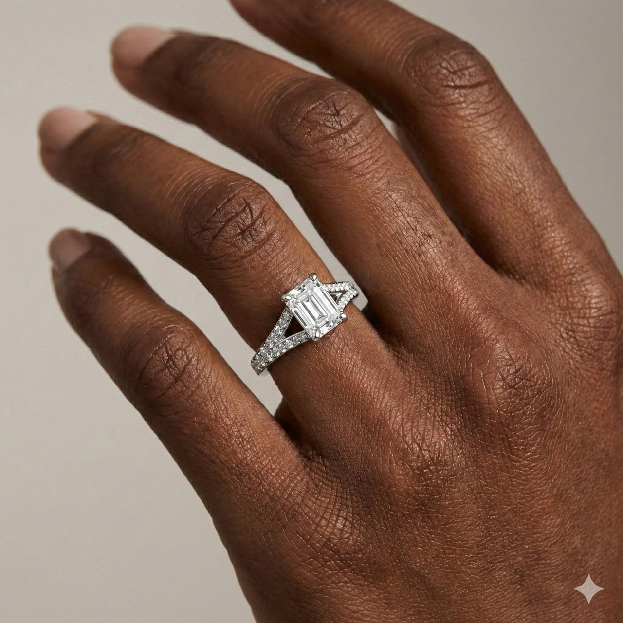 Emerald cut diamond engagement ring in 14k white gold with a diamond channel band and split setting on a hand
