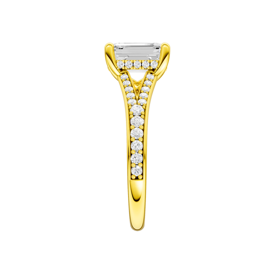 A side view of the Emerald cut diamond engagement ring in 14k yellow gold with a diamond channel band and split setting