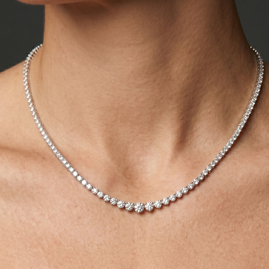 Lifestyle view of a model wearing a luxurious white gold or platinum graduated diamond tennis necklace featuring brilliant round-cut diamonds.