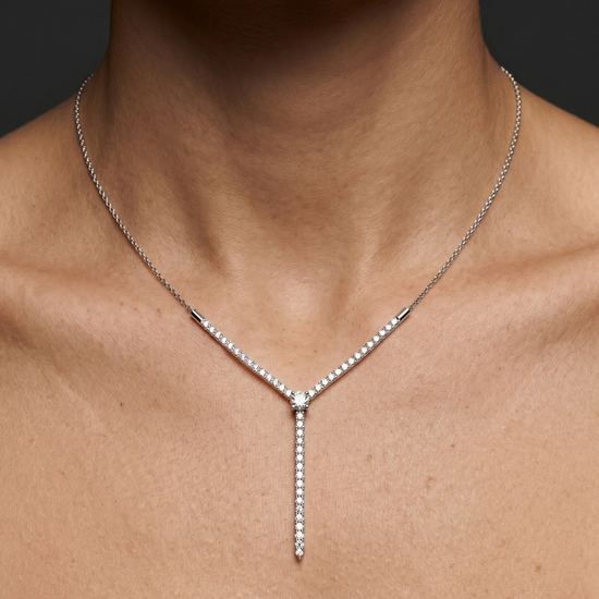 Amorati Valletta Diamond Strand Necklace in white gold worn on the model, featuring a V-shaped diamond design with a vertical diamond drop.