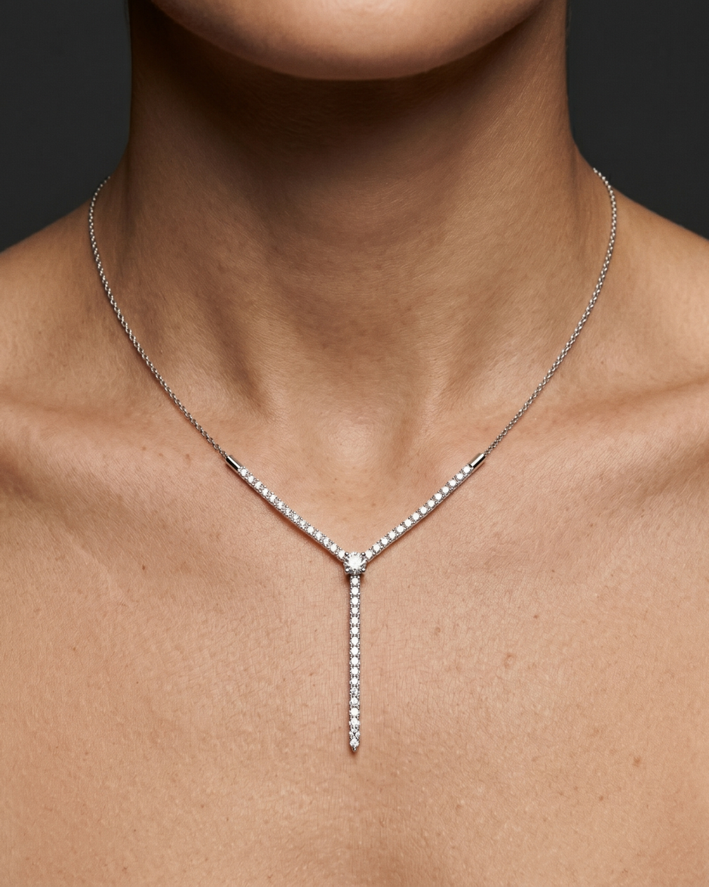 Amorati Valletta Diamond Strand Necklace in white gold worn on the model, featuring a V-shaped diamond design with a vertical diamond drop.