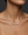 Lifestyle view of a white gold necklace worn on the neck, showcasing round white diamonds along a curved design.