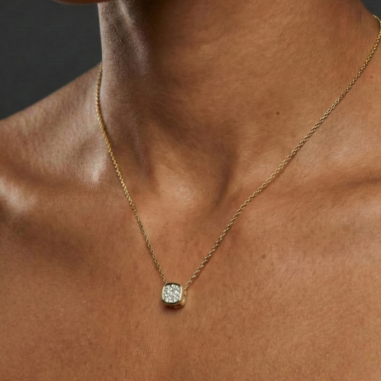 Yellow gold cushion cluster diamond necklace worn on figure, offering a warm glow and timeless everyday elegance.