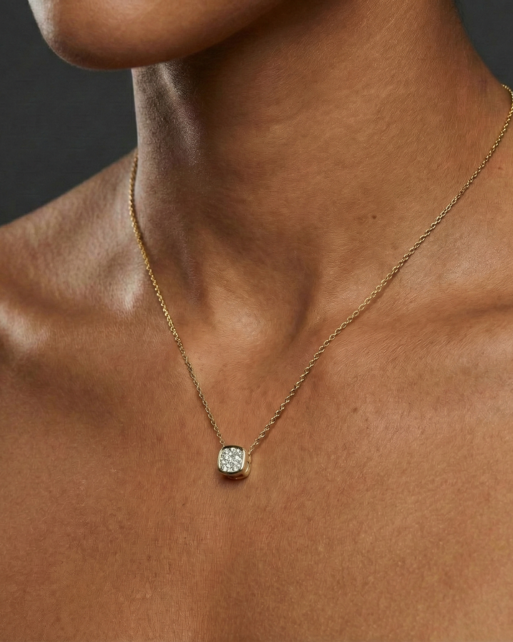 Yellow gold cushion cluster diamond necklace worn on figure, offering a warm glow and timeless everyday elegance.