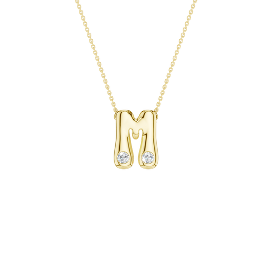 Modern 14k yellow gold bubble letter M initial necklace studded with two brilliant round-cut flush-set white diamonds on a delicate cable chain.