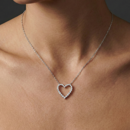 White gold petite diamond heart pendant necklace worn on figure, resting softly at the collarbone with subtle, everyday elegance.