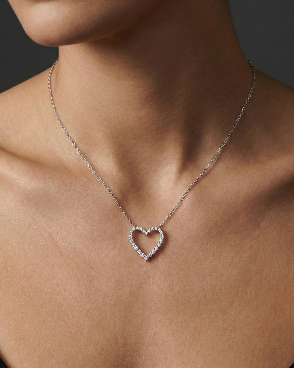 White gold petite diamond heart pendant necklace worn on figure, resting softly at the collarbone with subtle, everyday elegance.